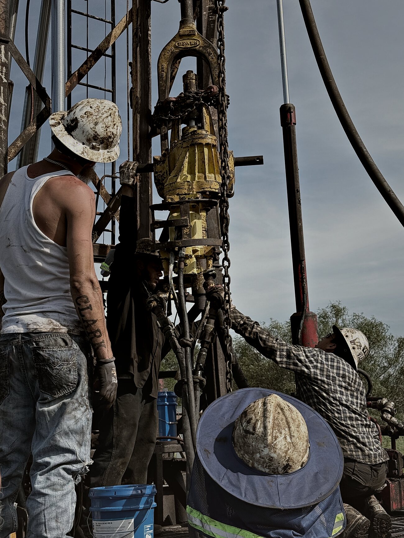 Crew rigging the power swivel on the workover rig at Vaughan Well No. 1